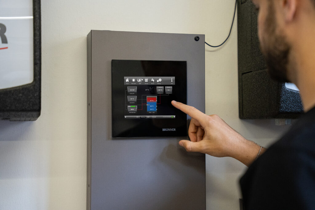 Mann deutet auf das Display der BRUNNER Control Unit BCU