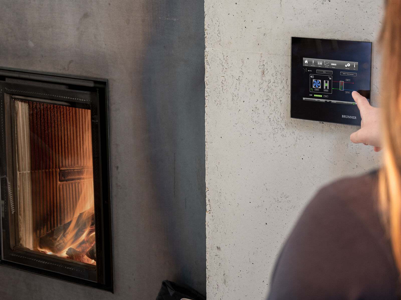 Frau deutet auf das Display der BRUNNER Control Unit BCU
