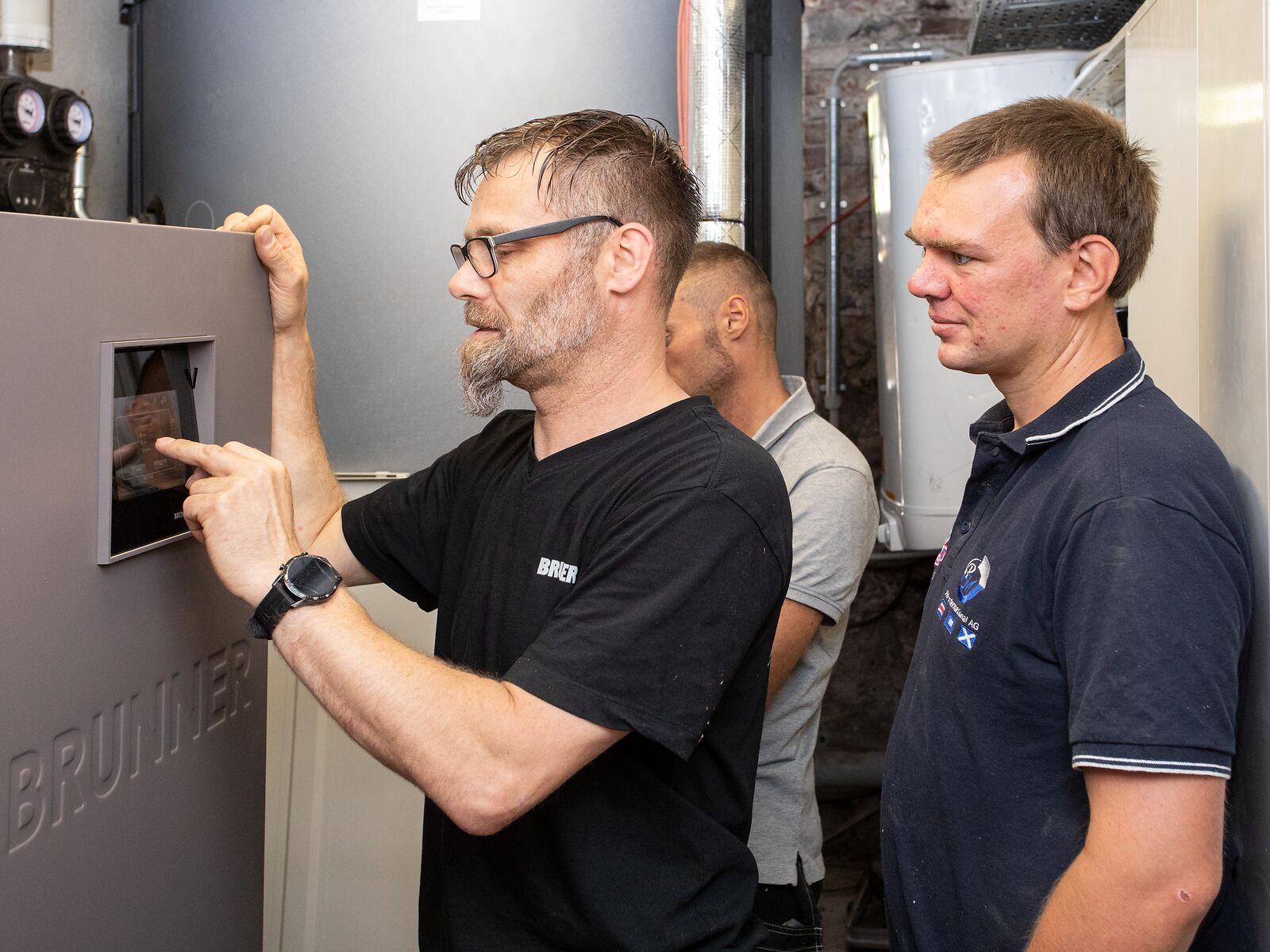 Kundendienstmonteur tippt an Steuerung von Pelletkessel