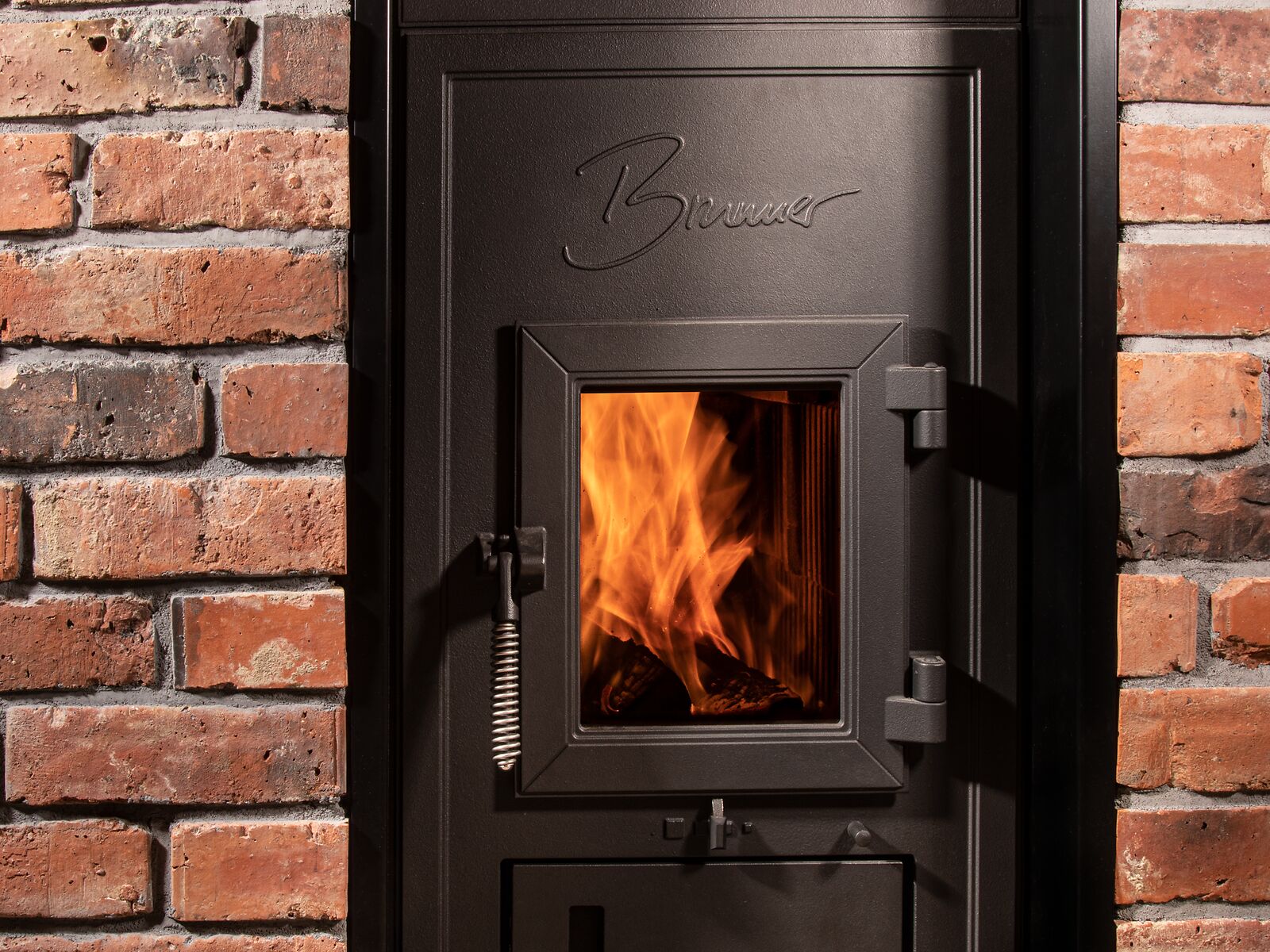 BRUNNER Kachelofen Austauschgerät mit Frontplatte in der Ziegelwand