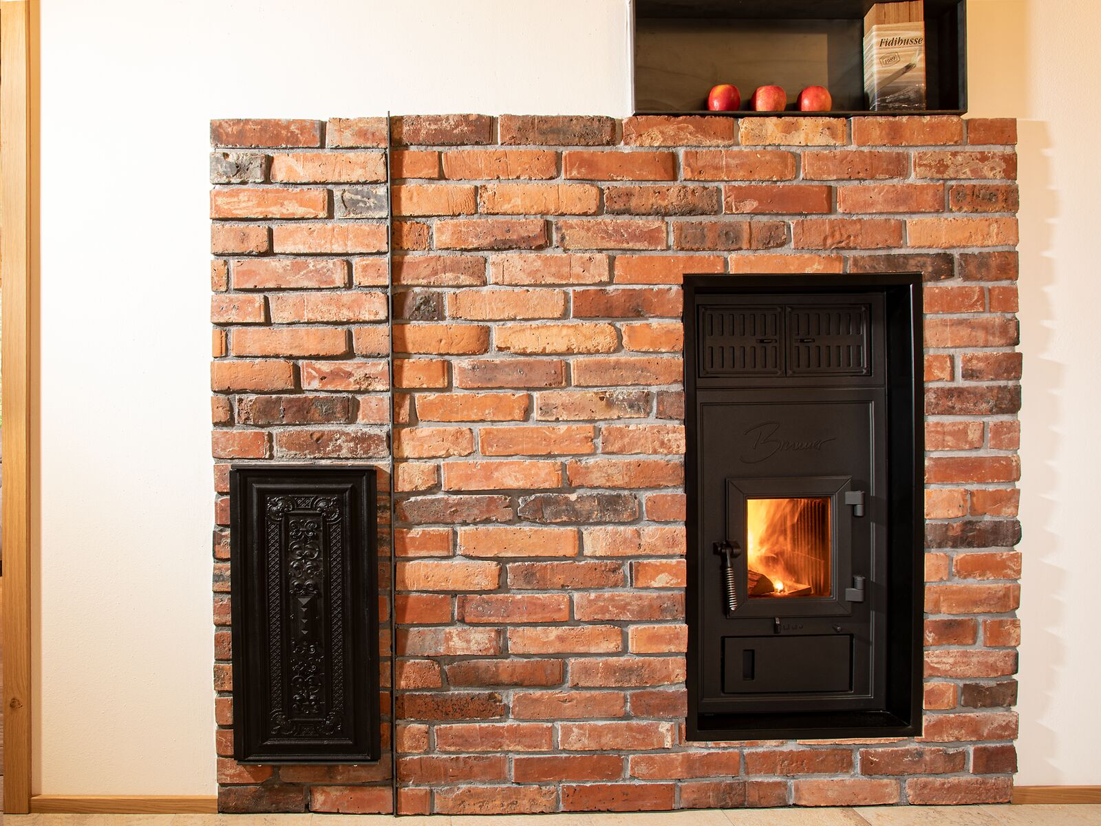 BRUNNER Kachelofen Austauschgerät mit Frontplatte in der Ziegelwand