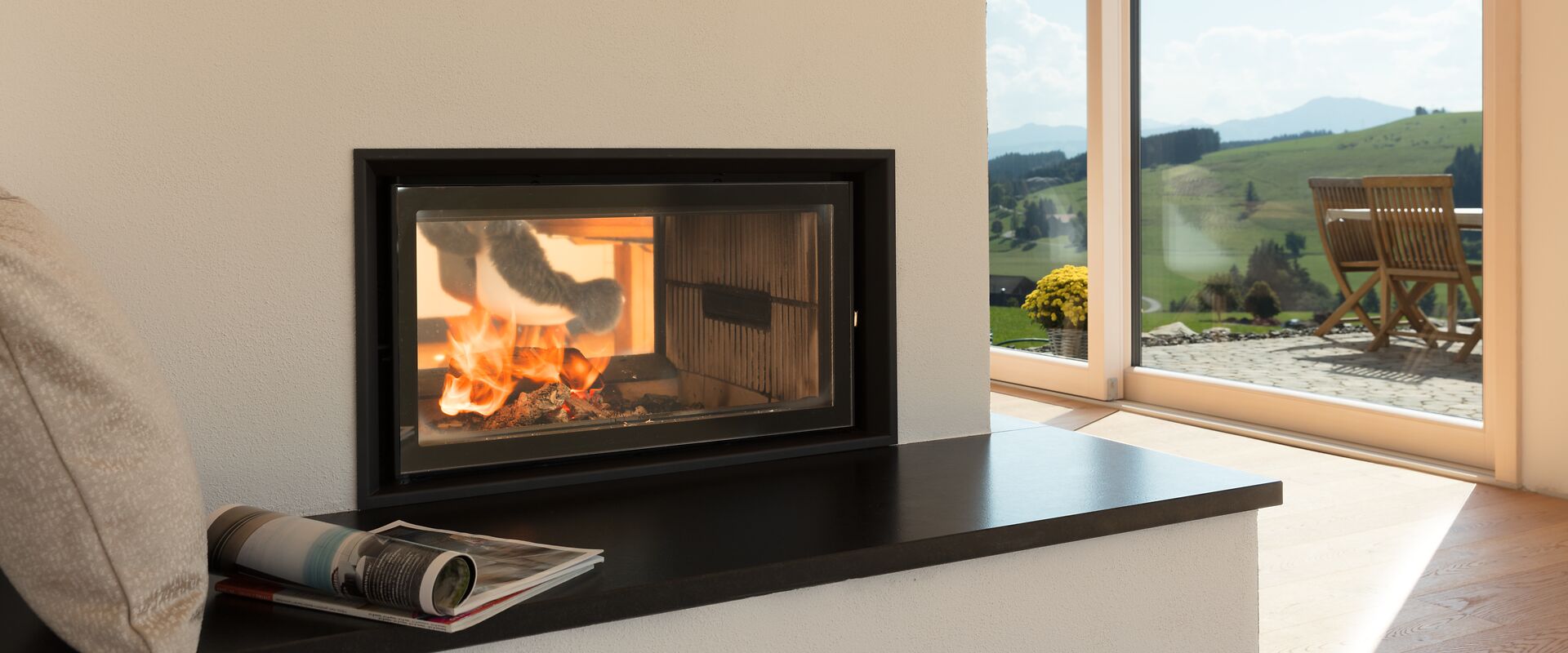 Tunnelkachelofen mit Ofenbank und Blick auf eine Terrasse