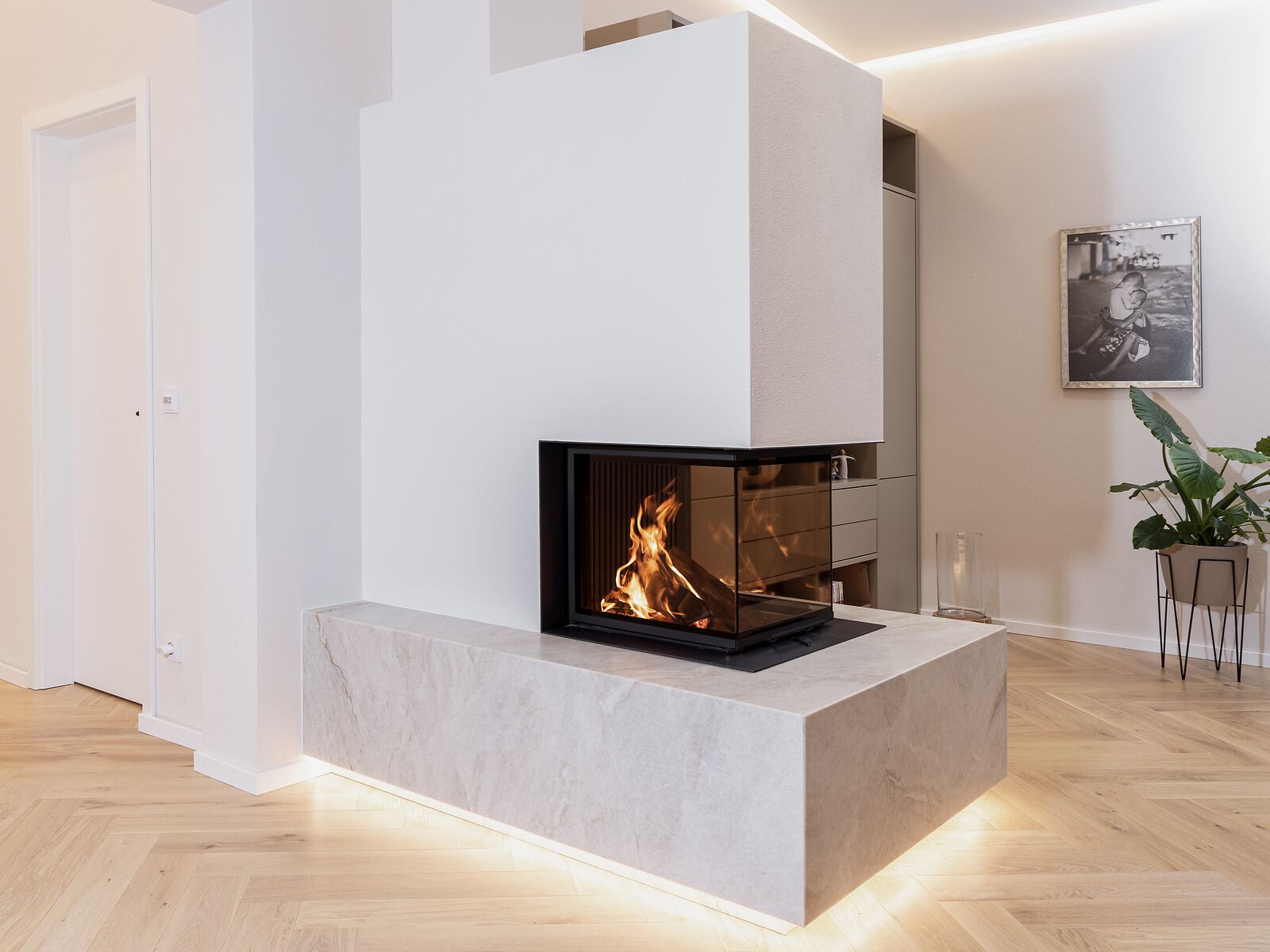 Heller Panoramakamin mit Feuertisch aus Stein und indirekter Beleuchtung