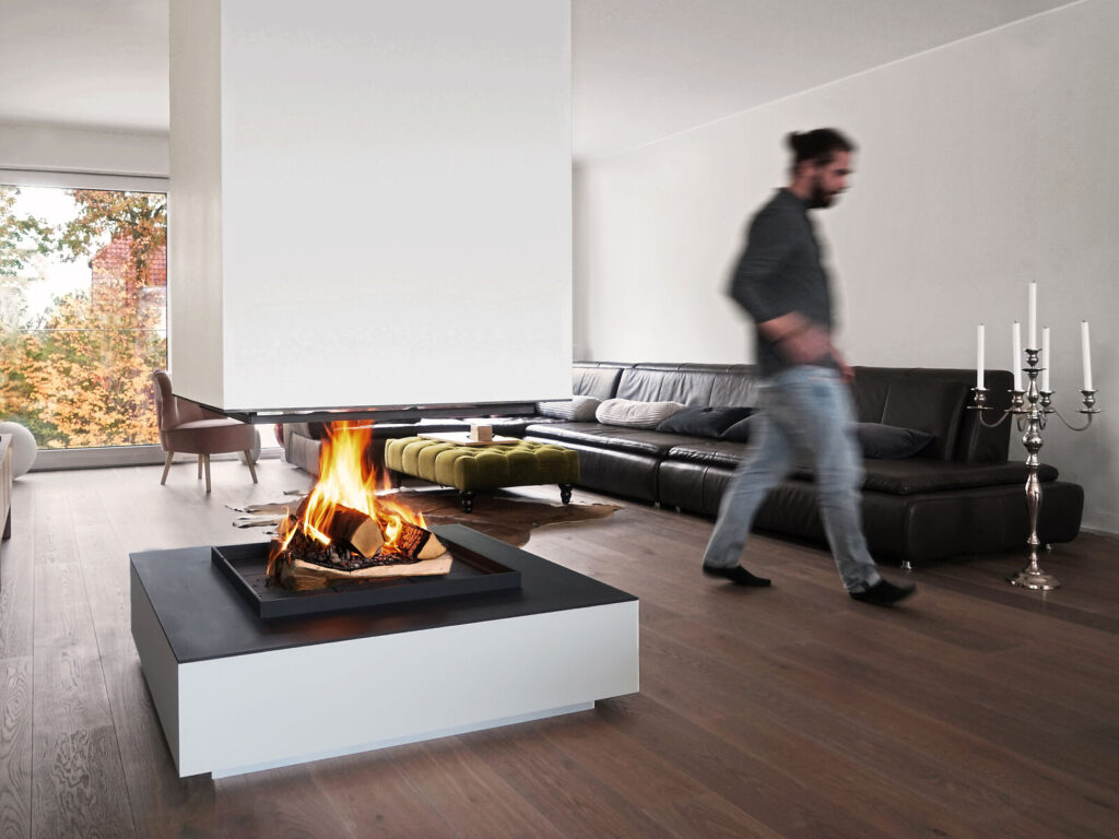 Offener Kamin Urfeuer 4 free in gemütlichem Wohnrimmer mit vorbeilaufender Person