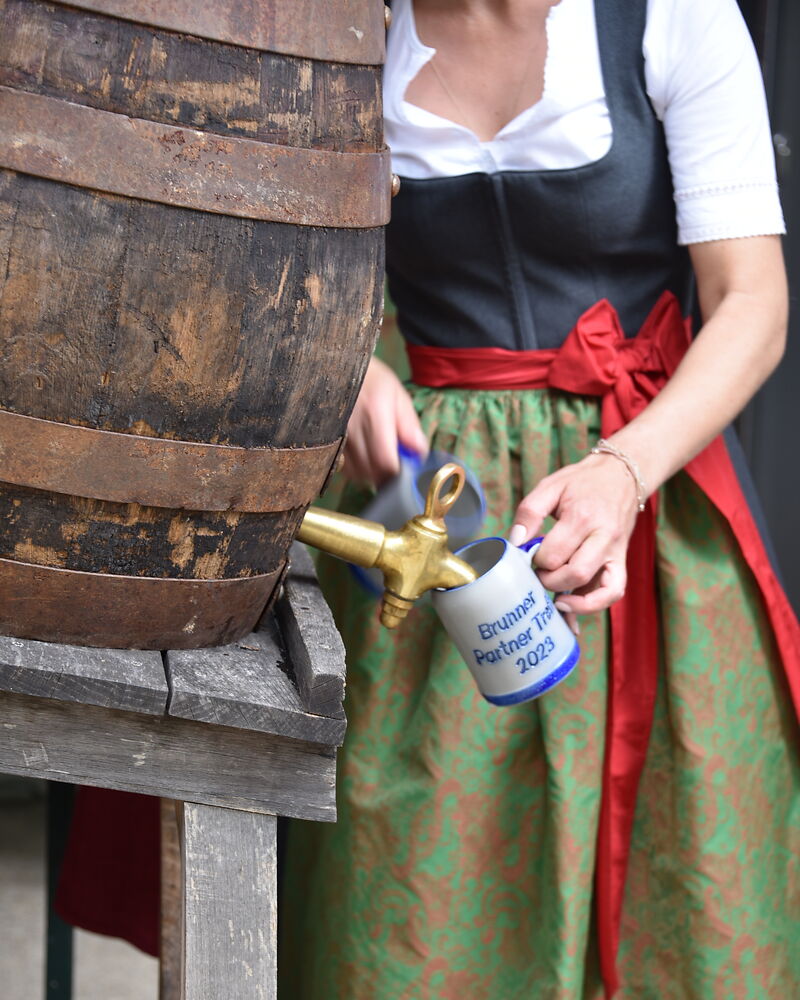 Frau zapft Bier aus einem Fass vom BRUNNER Partnertreff 2023