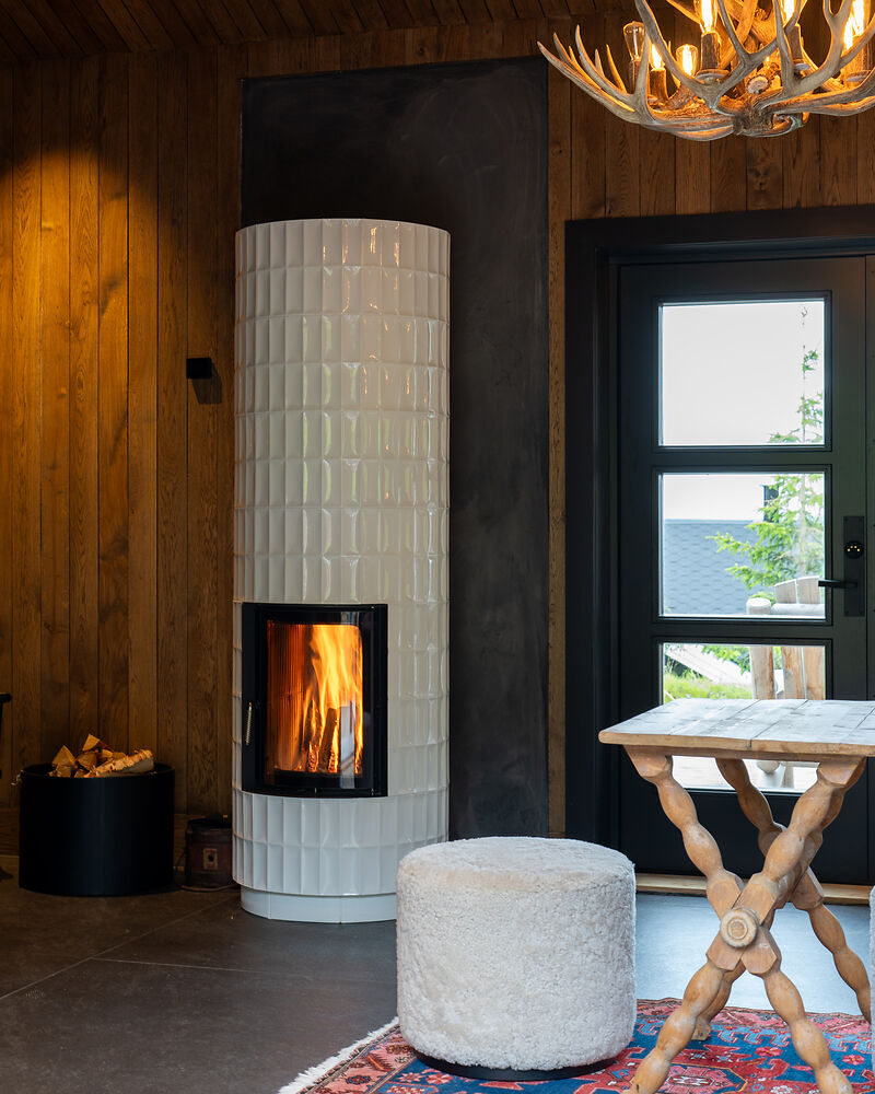 Skandinavischer Ofen mit weißen Kacheln im Wohnraum