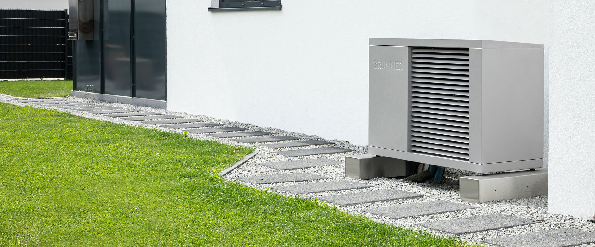 Wärmepumpe im Garten vor der Hauswand