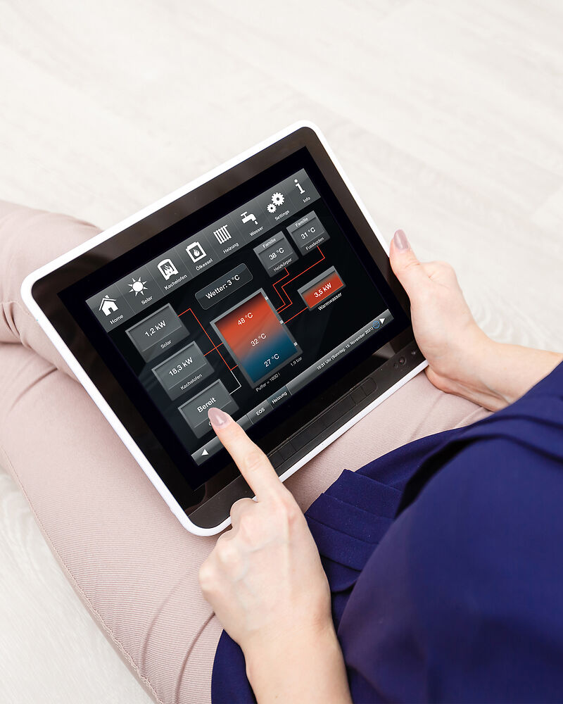 Startseite Heizungsansicht der BRUNNER Steuerung; Frau tippt darauf