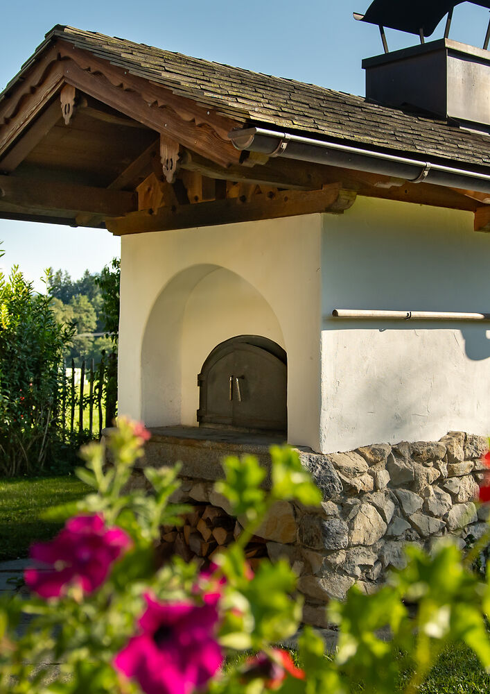 Das Feueriglu in einer Backofenhütte verbaut in einem schönen Sommergarten