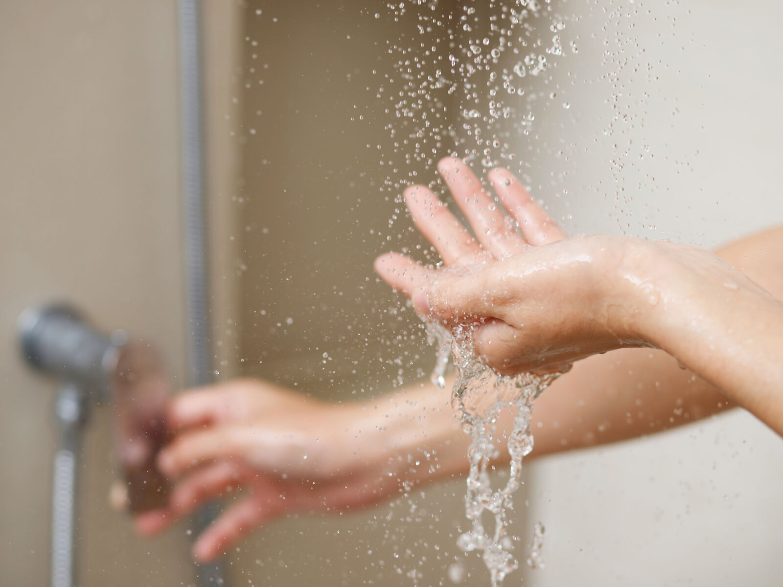 Hände mit Wassertropfen während des Duschens