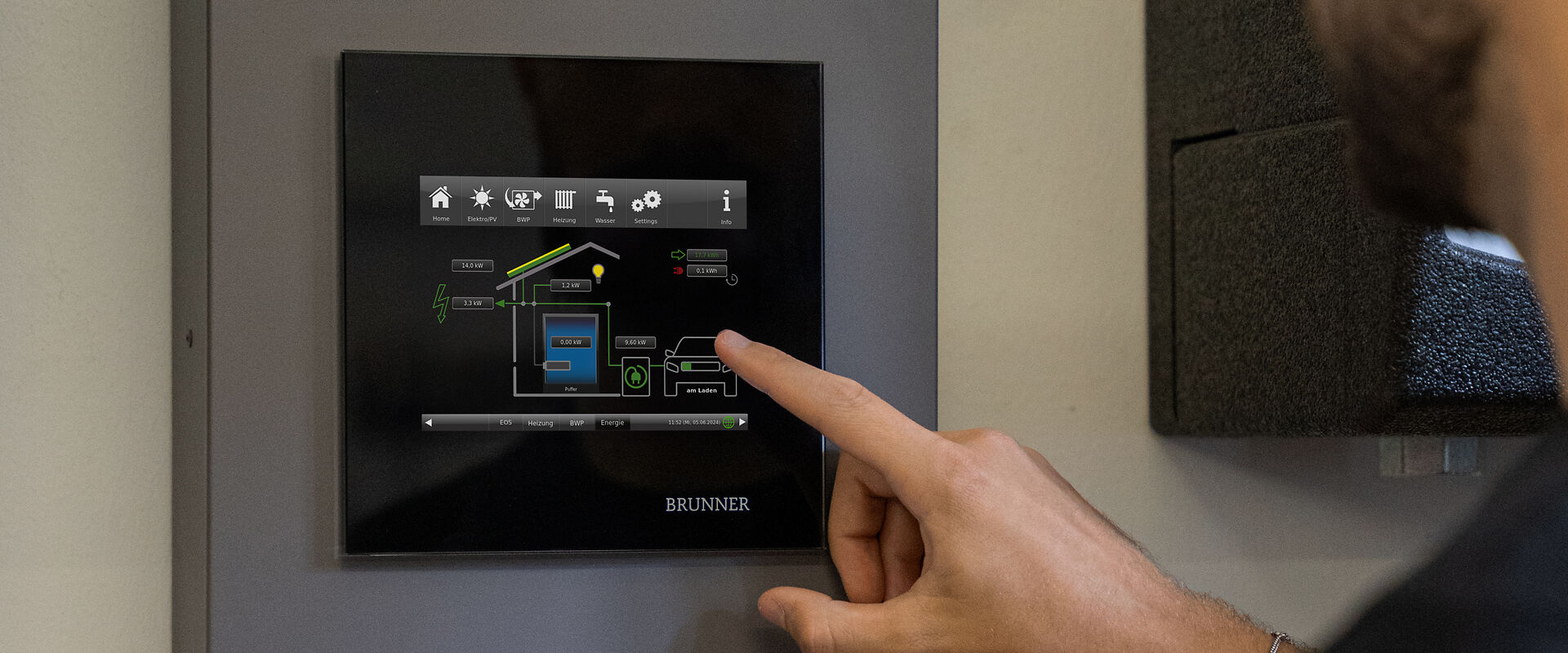 Mann zeigt die Displayansicht der BRUNNER Control unit BCU