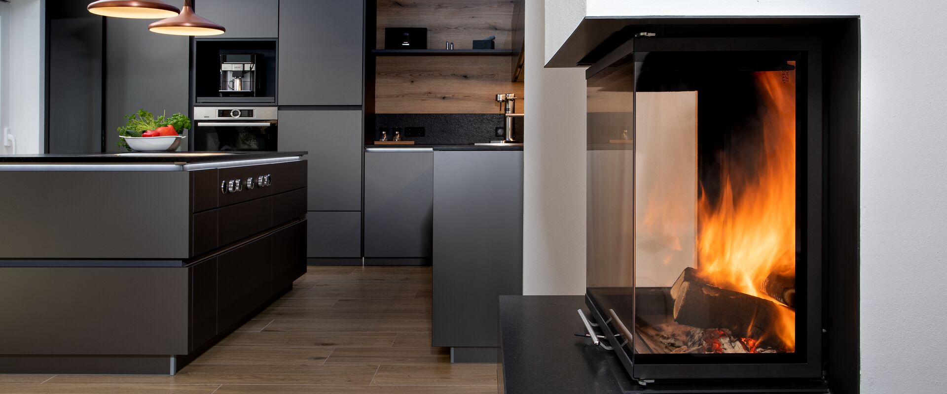 Kaminfeuer im Panoramakamin vor einer Küche